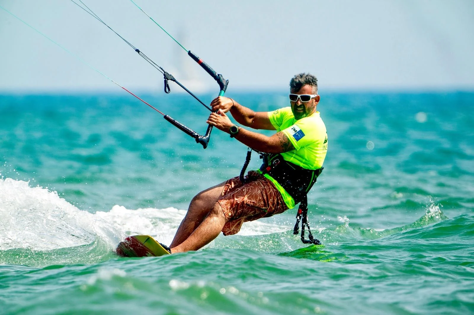 Istruttore King Kendze in kitesurf con la maglia gialla da istruttore