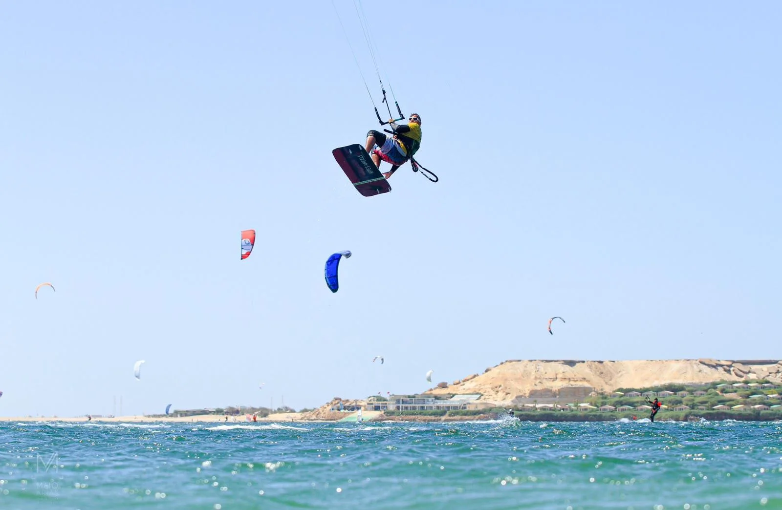 Kiter in salto sulla laguna di Dakhla, con la falesia di sabbia sullo sfondo